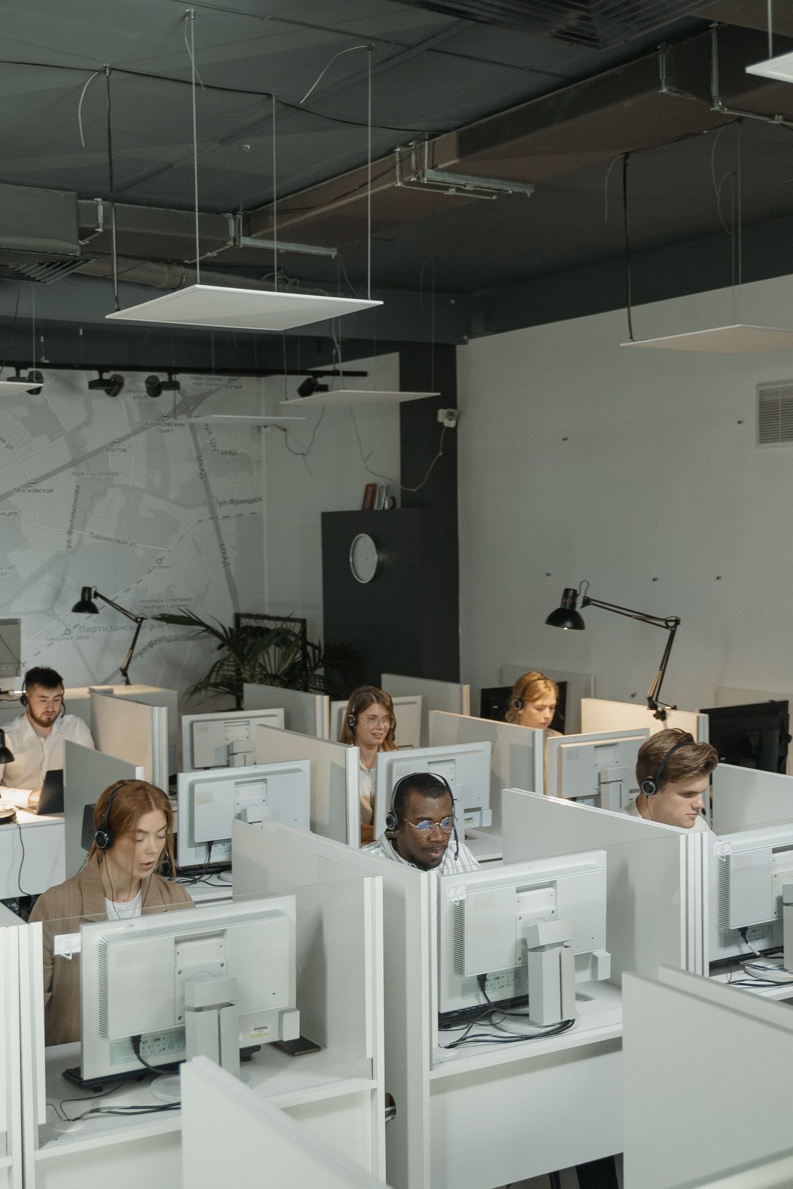Rows of agents wearing headsets working at desks on an office floor